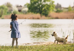 girl fishing with a dog